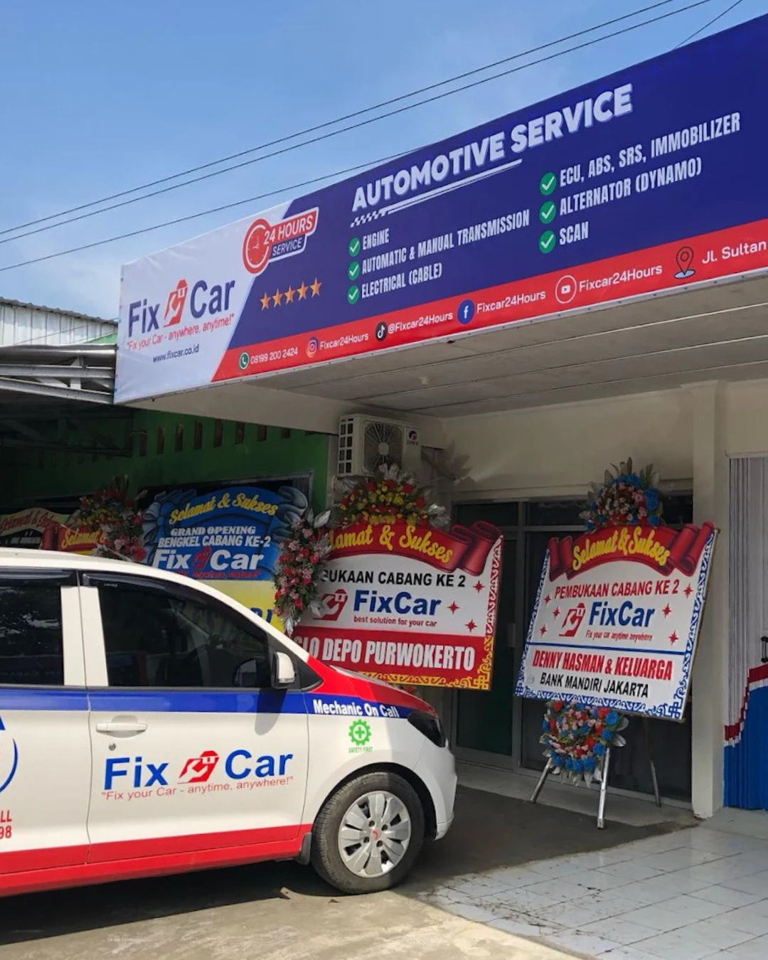 Modern automotive workshop with professional equipment and technicians working on vehicles